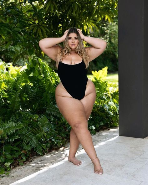 A woman poses outdoors in a black one-piece swimsuit, standing barefoot on a stone patio. She places her hands on her head, surrounded by lush greenery in the background Dark Beauty Photography, Top Summer Outfits, Positivity Quotes, Seductive Clothes, Curvy Women Outfits, Curvy Model, Flattering Dresses, Plus Size Swimsuits, Miami Florida