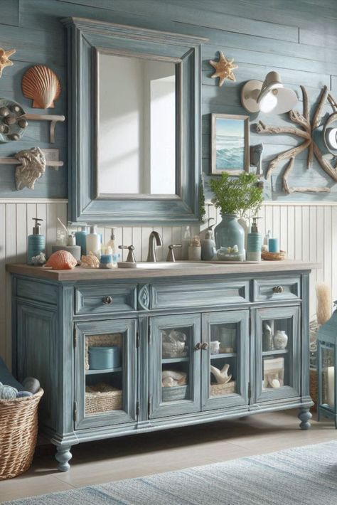 Bring beachy vibes to your bathroom with this weathered blue vanity. Perfect for a coastal-themed retreat. #CoastalDecor #BeachHouseStyle China Cabinet Bathroom, Bayou Cottage, Girl Vanity, Theme Bathroom, Blue Vanity, Ocean Girl, Beach Theme Bathroom, Cabinet Bathroom, Vanity Ideas