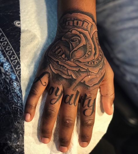 Men’s Hand Tattoos Writing, Money Rose Tattoo On Hand, Money Rose Hand Tattoo Men, Loyalty Hand Tattoos For Guys, Hand And Wrist Tattoos For Guys, Trap Tattoos Men Hand, Money Rose Tattoo For Men, Loyalty Over Love Tattoo For Men, Gangsta Hand Tattoos