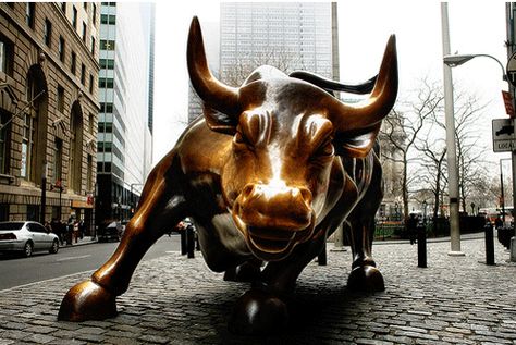 The bronze bull that stands in Bowling Green appeared in front of the New York Stock Exchange 12/15/89. It was created by the Italian artist Arturo DeModica who put the 7,000-pound bull in front of the New York Stock Exchange in the middle of the night without permission. It is a symbol of strength, power and hope of the American people for the future.  The Bull is an NYC landmark and a favorite stop for tourists. If you want fortune in the stock market, you have to rub the bull for luck. Stock Market Wallpaper, Market Wallpaper, Bulls Wallpaper, Blood Money, Charging Bull, New York Attractions, Investment Quotes, Bull Run, State Street