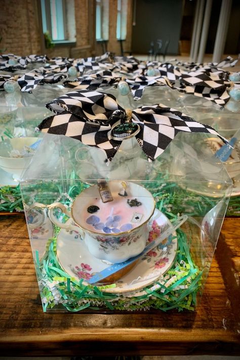 Bridal Party favors lined up on a table. Each bag contains a vintage tea cup and is sealed with a Alice in Wonderland-themed checkered bow. Mad Hatter Birthday Party, Outdoor Party Favors, Easter Tea Party, Candle Bridal Shower Favors, Alice In Wonderland Crafts, Surprise Birthday Decorations, Teacup Candle, Fairy Baby Showers, Alice In Wonderland Gifts