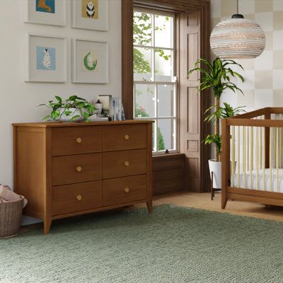 Mid-century modern, meet craftsman charm in the Babyletto Sprout 6-Drawer Double Dresser. Versatile in design and function, the Sprout 6-Drawer Dresser seamlessly moves from the nursery to a big kid room with the option to buy a removable changer top. Six spacious, smooth-glide drawers provide ample space for a growing babe’s wardrobe. Pair it with the Sprout 4-in-1 Convertible Crib for a classic mid-century modern nursery. babyletto Color: Chestnut babyletto Sprout 6 Drawer 19.75" W Double Dres Mid Century Modern Nursery, Big Kids Room, Glider Rocker, Stylish Nursery, Toddler Accessories, Nursery Crib, Convertible Crib, Kid Room, Double Dresser