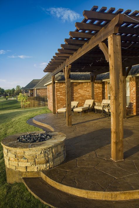 Fire pit situated right at the edge of a curved patio edge underneath a wooden arbor. All of this was crafted by Red Valley Landscape & Construction. Craftsman Patio, Stamped Concrete Patio Designs, Red Valley, New Patio Ideas, Curved Patio, Patio Edging, Curved Pergola, Patio Pictures, Patio Design Ideas