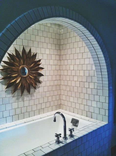 Exquisite bathroom features arched bathtub alcove accented with white square tiles and adorned with gold sunflower mirror. Bathtub Alcove Ideas, Bathtub Archway, Arched Bathtub, Bath Alcove, Tub Alcove, Bathroom Alcove, Alcove Design, Arched Bathroom, Chevron Tiles