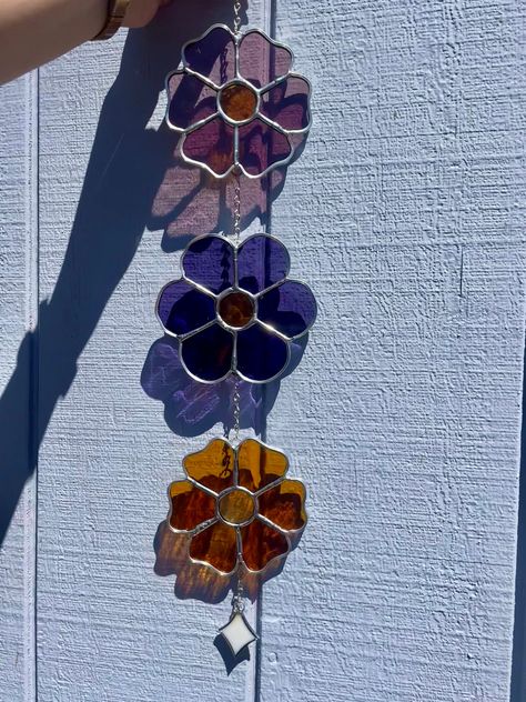 Introducing a set of three adorable handmade stained glass flowers! Each flower is crafted by hand and comes in a range of vibrant colors. Hang them together for a pop of color and charm in any room. These cute flowers are perfect for adding a touch of handmade beauty to your space! One flower is pink, one is orange, and the third is your choice!