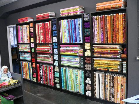 Black bookshelves for quilt shop bolt display Fabric Shop Interior, Fabric Shop Display, Quilt Shop Displays, Fabric Store Displays, Thread Rack, Fabric Store Design, Sewing Room Storage, Retail Store Interior Design, Clothing Store Interior