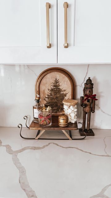 Jen Alvarez • Home Decor on Instagram: "Christmas coffee bar 🌲🤎 comment ‘Coffee Bar’ and I’ll send over the details to shop ✨ Bringing all the holiday warmth to the coffee bar! I fell in love with this pretty sleigh board and painted the bottom to make it more aesthetic ✨   Save for later 🤎🌲✨🫶🏼 & shop this post in my bio   #amazonhome #amazonfinds #bow #christmasdecor #christmastime #neutralchristmas #christmaspartyideas #holidayhostess #Itkhome #Itkholiday #itkunder25 #christmascoffeebar #christmasinspiration" Christmas Decor Ideas Coffee Bar, Coffee And Cocoa Bar Ideas, Coffee Bar Ideas Christmas, Sleigh Decorating Ideas, Holiday Coffee Bar, Christmas Coffee Bar, Christmas Bar Cart, Coffee Bar Ideas Kitchen Counter, Black Christmas Decorations