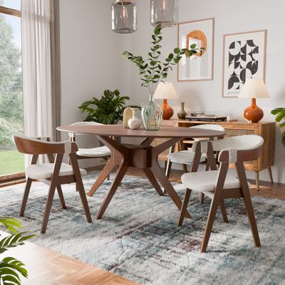 The mid-century modern 5-piece wood dining table set presents a chic dining table paired with chairs featuring plush boucle padding. Ideal for hosting guests, the table's contoured legs provide stability, while the chairs' curved backrests with open bottom halves offer a contemporary flair. All together, this dining set combines style and functionality, making it a standout addition in any dining area. Enitial Lab | Enitial Lab Michio 5-Piece Dining Table Set Wood / Upholstered in Brown | 4 | Wayfair Mid Century Dinner Table, Mid Century Modern Kitchen Table, Modern Mid Century Dining Room, Mid Century Modern Dining Room Table, Midcentury Modern Kitchen Table, Mid Century Kitchen Table, Midcentury Modern Dining Room, Mcm Dining Table, Mid Century Modern Dining Table