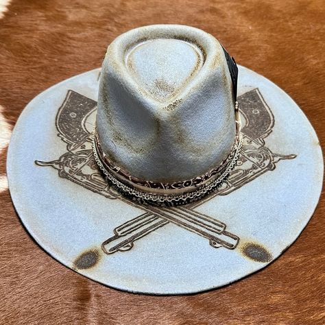 The Gambler cowboy hat for cowgirls is custom burned by Calamity Anne exclusively for Bourbon Cowgirl! Featuring dueling pistols, the phrase "Bet Against Me That Will Be Fun" and a beautiful wine and white paisley hat band with silver chain and black leather. Matches and a torched Ace of Hearts and Tennessee Whiskey card are stashed in the hat band. Two .40 caliber brass casings are lodged in the crown for a fun accent. One size fits most, as the interior band is adjustable to fit most. A beauti Diy Hat Band, Calamity Anne, Hat Customization, Desert Grunge, Cowboy Shooting, Burned Hats, Hat Burning, 40 Caliber, Custom Cowboy Hats