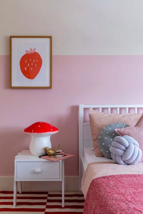 A candy pink border gives this cheerful kids room from Eklektik Studio a lively spring feel that is accented with pops of strawberry pink and red that adds depth and makes it work year-round. #pinkbedroom #paintcolors #springdecor #springtablescape #springpaintcolors #homedecorideas #thespruce