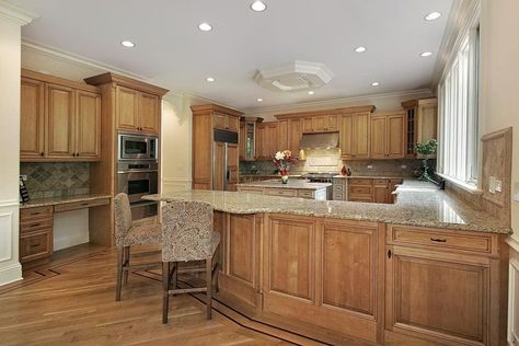 Kitchen with pecan cabinets, countertop, wood flooring, backsplash, windows, and ceiling lights Pecan Cabinets, Medium Wood Cabinets, Light Backsplash, Modern Kitchen Colours, Modern Wood Kitchen, Light Wood Kitchens, Maple Kitchen Cabinets, Brown Kitchen Cabinets, Light Wood Cabinets