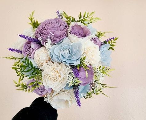 Soft blue and light purple wood flowers are the perfect pair in this bridal bouquet!  Wood flowers are custom dyed in light,  spring shades and accented by babies breath and faux greenery.   This bouquet, as pictured, measures about 10 inches in diameter.  Message me to request a custom order! To purchase matching boutonnieres, look here: https://www.etsy.com/shop/mydinosaurdreams/?section_id=21264911 To purchase matching corsages, look here:  https://www.etsy.com/shop/mydinosaurdreams/?section_ Lilac And Blue Bouquet, White Blue And Purple Wedding, Wood Flower Wedding Decor, Light Blue And Purple Wedding Flowers, Lavender And Sky Blue Wedding, Light Blue And Purple Bouquet, Lilac Dusty Blue Wedding, Purple And Blue Flowers Wedding, Purple And Dusty Blue Wedding