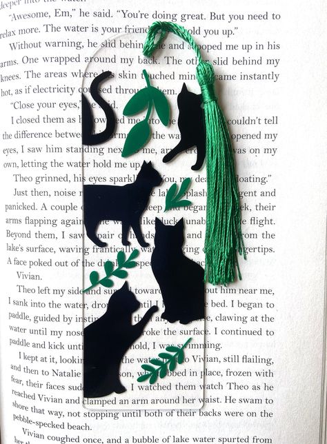 A clear acrylic bookmark with black cats and plants! Each bookmark is carefully hand crafted and includes a tassel as shown. -The cats and plants are made from permanent vinyl. Each piece is hand placed, so it may slightly differ from the photo Cat Book Marks, Acrylic Bookmarks Vinyl, Cute Bookmarks Ideas, Acrylic Bookmark Ideas Aesthetic, Diy Acrylic Bookmark Ideas, Acrylic Bookmark Ideas Vinyl, Cricut Acrylic Bookmark Ideas, Cool Bookmark Ideas, Patterns For Bookmarks