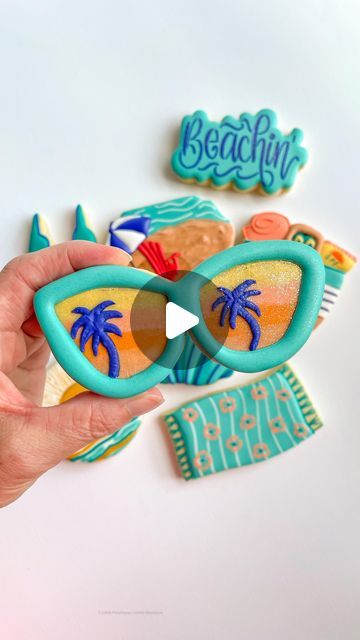 Victoria Jones | Decorated Sugar Cookies | Keller, TX on Instagram: "Just getting ready for our annual trip to LaJolla with this pair of beach themed sunglasses decorated sugar cookie!! 

One thing I learned from scraping royal icing….the best consistency for this is outline consistency. Also, make sure you scrape down any thick areas on the edges of the scraped icing so you don’t struggle with piping the rest of your design!!

Cutter @killerzebras 
DiamondDust and icing colors @thesugarart - use code LPC10 for 10% off!
Edible food pen @dripcolorlatam 

#sunglassescookies #summercookies #beachcookies #decoratedcookies #cookiesofinstagram #royalicing #cookiedecorating #decoratingcookies #cookiedecoratingvideo #cookiedecorator #customcookies #designercookies #fashioncookies #icingcookies" Beach Sugar Cookies, Sunglasses Decorated, Decorated Sugar Cookie, Beach Cookies, Cookie Videos, Icing Colors, Summer Cookies, Edible Food, Cookies Decorated