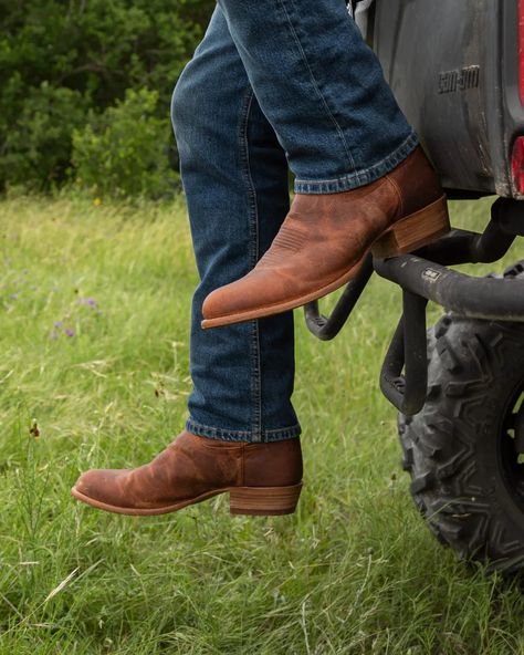 Our original cowboy boot is timelessly styled to look as good in 50 years as it does today. Its ageless nature starts with a classic round toe and 1 ½” stacked angled heel, and builds upon it with a vamp adorned with signature Tecovas toe stitching. A 12” shaft with hand-laid cording and reinforced pull straps complete its iconic western flair. You’re spoiled for choice: whether that be ultra-soft calfskin, rugged bovine, or quick-to-patina goat. Suited up for an outdoor wedding, or decked out i Brown Cowboy Boots Outfit, Square Toed Boots, Boots Outfit Men, Brown Cowboy Boots, Western Style Boots, Western Jeans, Formal Loafers, Mens Cowboy, Men’s Boots