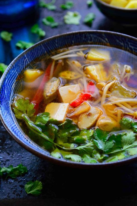 This Vietnamese sour soup recipe is ready in just 15 minutes and so full of complex flavours and textures that it just might be the most delicious bowl of soup you’ve ever tasted. This is a vegetarian version of canh chua with tamarind, pineapple, okra and silken tofu. The combination seems weird but I’m sure it will quickly become your new favourite soup! Tamarind Soup Recipes, Polynesian Dishes, Tamarind Soup, Sour Soup Recipe, Canh Chua, Vietnamese Dishes, Vietnamese Soup, Okra Recipes, Vegetarian Soup Recipes