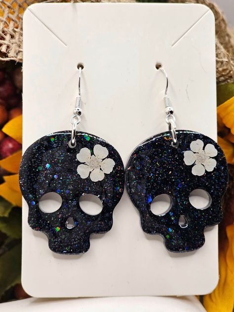 These beautiful black Glitter Skull and real white pressed flowers earrings are handmade and designed by BellaTreasuresByMT. They can be made in any color glitter with any real flower color choices.  If you do not see an option, message me and I can make you anything you desire.  They can also be made to glow in the dark if requested. Halloween Resin Jewelry, Fall Resin Jewelry, Halloween Resin Earrings, Resin Clips, Resin Things, Diy Resin Earrings, Glitter Skull, Halloween Resin, Laser Crafts