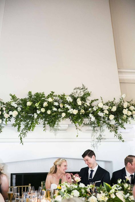 Fireplace Mantle Florals Wedding, Mantel Arrangements, Mantle Floral Installation, Sweetheart Table Cascading Flowers, White Florals Sweetheart Table, Garland On Mantle, Sweetheart Table Florals White And Green, Fireplace Wedding, Wedding Mantle