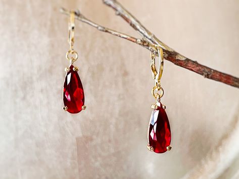 "Teardrop garnet gemstone drop earrings in 14K yellow gold filled. Each earring dangle features an elongated 17x6mm teardrop garent. Polished to a bright shine and secured with lever back huggies. Shipped in beautifully wrapped gift box ready for gifting. Approximate measurements: Earrings: Length = 35mm, 1.4\" Width = 7mm, 0.3\" Drop = 21mm, 1.8\" Total weight = 3.8g" Garnet Teardrop Earrings, Minimalist Earrings Gold, Gemstone Drop Earrings, Forest Hills, Teardrop Dangle Earrings, Birthstone Earrings, Garnet Jewelry, Red Gemstones, January Birthstone