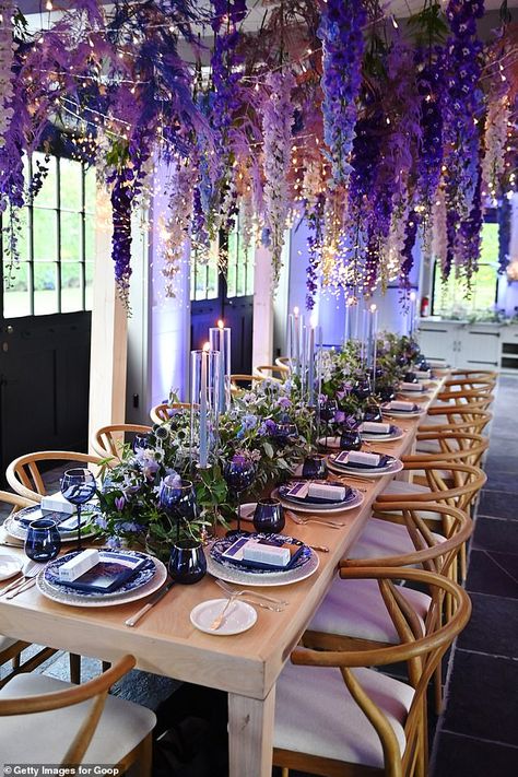 Gorgeous: The event culminated in a meal at long dining tables decorated with gorgeous violet flowers hanging from the ceiling over the guests Fake Flowers Hanging From Ceiling Bedroom, Lavender Hanging From Ceiling, Flowers Hanging Over Table Wedding, Flower Dining Table, Hanging Purple Flowers, Wedding Flowers Hanging, Purple Flowers Hanging From Ceiling, Flowers From The Ceiling, Ceiling Flower Decoration