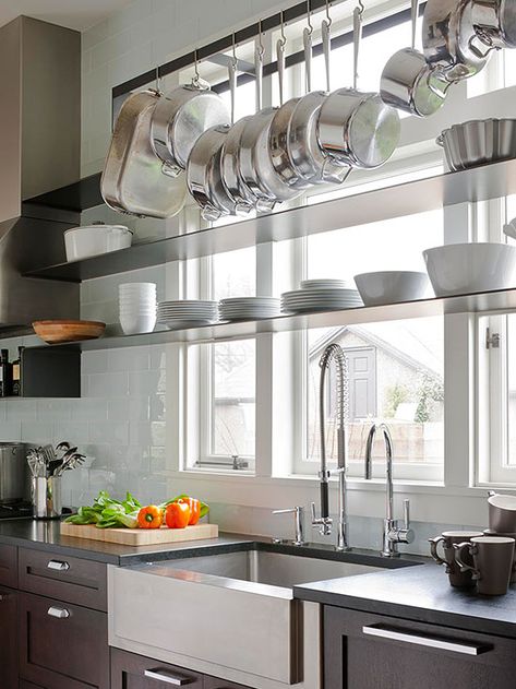 Natural light is a boon in small spaces, helping to brighten dark corners and make tight rooms feel bigger. But windows can also gobble up potential storage spots. To get the best of both window-focused worlds, consider a strategy used in this kitchen: a mid-height shelf for a few short bowls, and a hanging rack near the ceiling for essential pots and pans. Pan Storage Diy, Pan Storage, Kitchen Clutter, Hanging Rack, Small Space Diy, Dark Corners, Hanging Pots, Space Decor, Trendy Kitchen