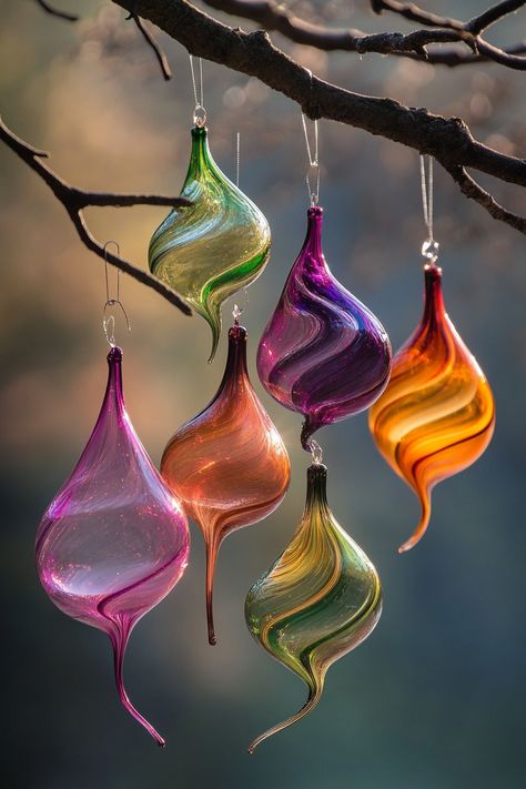 Colorful hand-blown glass ornaments with unique textures hang from a tree branch, softly illuminated against a blurred Trendy Christmas Decor, Luxury Christmas Decor, Faux Fur Tree Skirt, Earthy Living Room, Festive Table Setting, Rose Gold Decor, Christmas Planters, Unique Textures, Holiday Tree Decorations