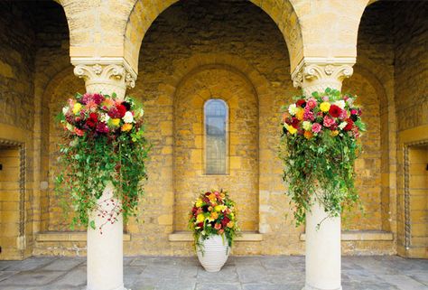 Decorated columns make a floral frame for photographs. The central arrangement includes roses, lilies, chrysanthemums, dahlias and contoured willow. Column Floral Arrangements, Wedding Columns Decor, Black Tie Wedding Decor, Pillar Decor, Pillar Decorations, Wedding Columns, Columns Decor, Gazebo Decorations, Greenery Wedding Decor