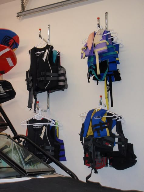 How To Store Life Jackets In Garage, Storing Life Jackets, Life Vest Storage, Lake Tube Storage Ideas, Lake House Garage Organization, Life Jacket Organization, Lifejacket Storage Garage, Boat House Storage, Boat Dock Storage Ideas