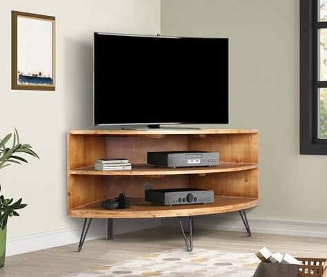 A corner TV console sure to help you put your furniture in the most practical spots, even if you want everything facing the TV in your L–shaped living room. Corner Media Stand, Wood Corner Tv Stand, Corner Tv Stands, Lodge Homes, Corner Tv Stand, Corner Tv, Cool Tv Stands, Media Stand, Desain Furnitur Modern