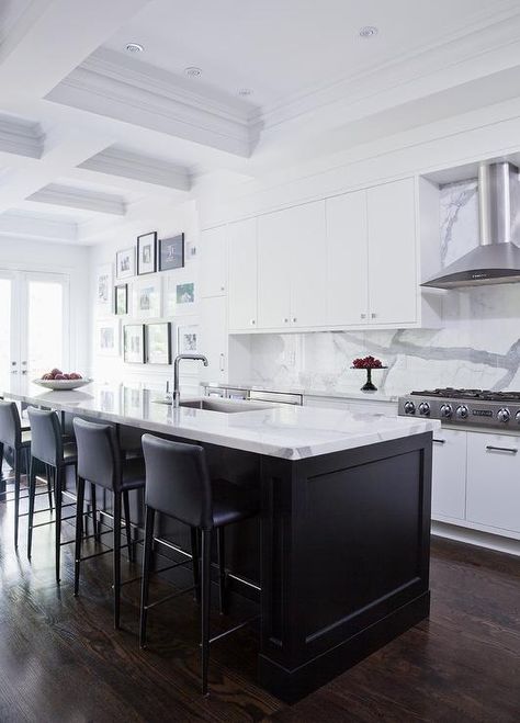 Black and white modern kitchen boasts black leather dining chairs placed at a long black center island topped with a white and gray marble countertop holding a stainless steel sink with a polished nickel faucet. Black Marble Countertops, Nickel Faucet, Black Leather Dining Chairs, Polished Nickel Faucet, Black Island, Black Kitchen Island, Condo Kitchen, Kitchen Black, Gray Marble