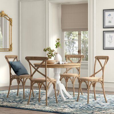 This 5-piece dining set brings an antique-inspired look into your dining room with its eye-catching curved lines and muted tones. It includes a round dining table and four chairs. All pieces are made from solid pine wood, with the tabletop and chairs finished in a natural light brown for a cottage feel. It's been gently distressing to bring out the wood grain and contrast with the white-hued pedestal base. The chairs feature a cross-back design for an airy look while the seats are upholstered in Cottage Dining Chairs, Beach House Dining Table, Small Breakfast Table, Small Dining Sets, Harvest Tables, Rustic Farmhouse Dining Table, Round Dining Room Sets, Kitchen Table Set, Coastal House