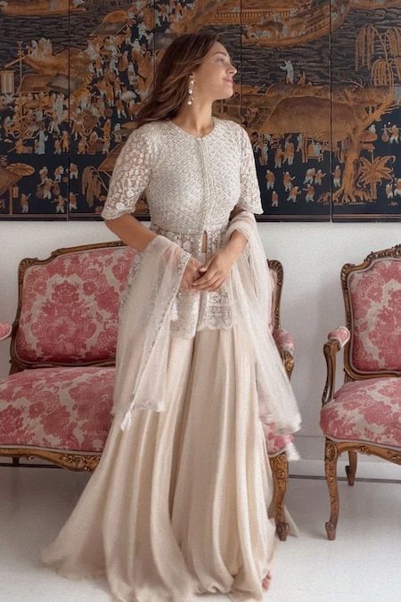 Buy Ivory Net Embroidery Thread Round Peplum Kurta Sharara Set For Women by SAISHA Online at Aza Fashions. Anarkali Sets With Pearl Embroidery In Cream, Elegant Semi-stitched Lace Work Sharara, Cream Lace Work Sets For Reception, Elegant Floor-length Sharara For Ceremony, Anarkali Cream Sharara With Pearl Embroidery, Cream Anarkali Set With Lace Work, Elegant Cream Sets With Lace Work, Festive Off White Sets With Lace Work, Anarkali Sharara For Ceremonies