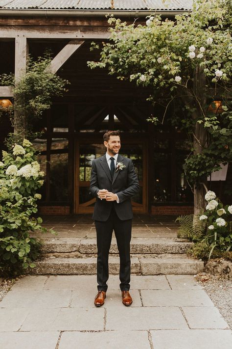 Groom in dark grey suit and brown leather shoes Groom Attire Dark Grey, Groom Suit Relaxed, Charcoal Suit Fall Wedding, Dark Charcoal Suit Wedding, Charcoal Suit With Brown Shoes, Dark Grey Wedding Suit Groom Attire, Groom Suit Outdoor Wedding, Rustic Groom Suit, Charcoal Grey Suit Men Wedding