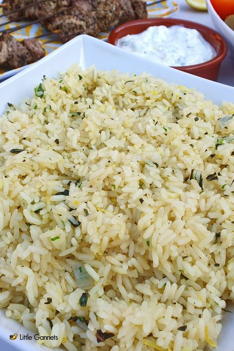 Rice in a bowl- Rice has herbs, onions and lemon mixed through it to make a delicious, fresh tasting dish for summer. In the background there is Tzatziki dip and pork souvlaki. Taziki Rice Recipe, Falafel And Rice, Recipes With Taziki Sauce, Jimmy The Greek Rice, Greek Style Rice, Greek Rice Salad, Greek Rice Recipe, Taziki Sauce, September Meals