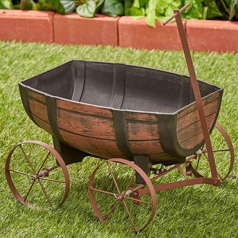 PRICES MAY VARY. Now you can display flowers and plants to create stunning seasonal displays with this charming planter. Styled to look like a nostalgic wagon, it features a realistic faux wood finish and smooth iron wheels. Includes a drainage hole at the bottom. Weather resistant plastic and iron. The planting area is approx. 16"L x 11"W x 5 1/2"H. Wagon measures 16 1/2"L x 14 1/2"W x 11"H, 34"L with handle. Barrel Flowers, Wagon Planter, Barrel Planter, Farmhouse Garden, Porch Garden, Outdoor Garden Decor, Rustic Outdoor, Whiskey Barrel, Flower Planters