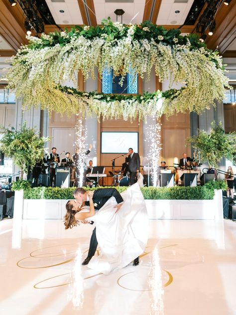 Starting at the Notre Dame football field, then leading into the extraordinary ballroom with a golden monogrammed dance floor, and lavish circular chandeliers dressed with lush hanging greenery, not a single detail was left out. Arlen Music Productions created an unforgettable and entertaining night for these newlyweds and guests. The spectacular music, contagious energy, and sparklers flying from the DJ booth brought everyone to the exquisite dance floor to dance the night away. Hanging Greenery, Circular Chandelier, Beautiful Centerpieces, Soft Seating, Ceiling Decor, Delphinium, First Dance, Dance Floor, In Bloom