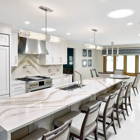 #ThrowbackThursday to one of our favorite kitchen transformations! Check out this inspirational render to the actual finished kitchen. This past project turned a standard kitchen into a culinary masterpiece. 

We started with a stunning cambriasurfaces Brittanic Gold quartz countertop as the centerpiece, complemented by monogramappliances built-ins for a sleek, high-performance touch. The Kohler sink paired with a Brizo faucet adds functionality and style, while lexingtonhomebrands counter stools and chairs offer chic, comfortable seating. woodharbor Cabinetry provides custom, high-quality storage solutions, and Artistic Tile marble flooring brings timeless luxury to the space. Natural light floods the kitchen through HR Skylights Sun Tunnels, creating a bright, inviting atmosphere. 

#TBT Brittanica Gold Cambria Quartz, Brizo Faucet, Sun Tunnels, Kohler Sink, Waterfall Countertop, Fireplace Furniture, Cool Background, Standard Kitchen, Cambria Quartz