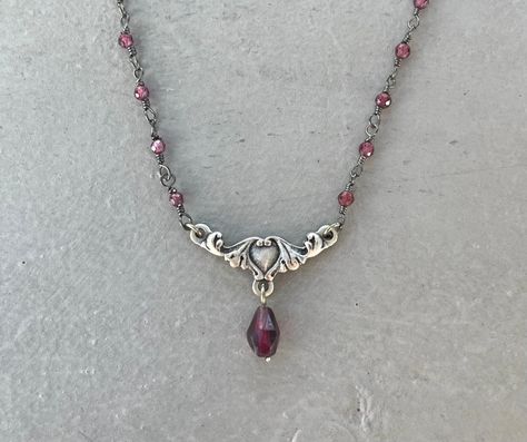 This dainty necklace is handmade using a 2mm genuine garnet rosary chain and a 18mm x 9mm heart connector with a 5mm garnet drop charm. A gold version is also available in my shop. This necklace is hypoallergenic. (Cadium free, lead free, and nickel safe) Garnet is an energizing stone that promotes passion and love.  The necklace comes in a ribbon-wrapped box, ready to be gifted. If you would like to leave a note for the recipient, you can do so during checkout. Garnet Rosary, 90s Necklace, Jewelry Fancy, Rosary Necklace, Crystal Necklaces, Garnet Necklace, Nail Jewelry, Dope Jewelry, Rosary Chain