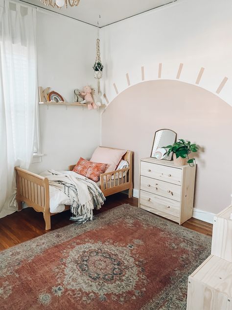 Toddler girl bedroom. Sunshine pink wall for boho style bedroom. Painted Sun creates a bold design in bedroom for little girl. #littlegirlbedroom #littlegirlbedroomstyle #bedroomstyleforlittlegirl #littlegirlroom #bohostylelittlegirlroom #sunshinewall Sun Wall Painting Bedroom, Sunshine Painted On Wall, Boho Pink Toddler Room, Painted Sun On Wall, Boho Kids Bedroom Girl Rooms, Sunshine Bedroom Kids, Toddler Wall Paint Ideas, Toddlers Bedroom Girl, Toddler Room Aesthetic