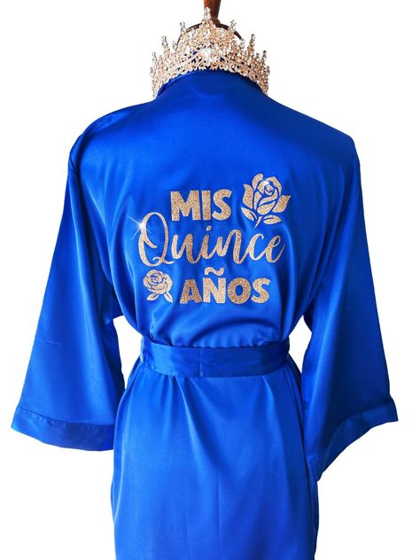 "Get ready for your Mis Quince Años celebration in style with our Quinceañera Satin Robes!  Crafted from soft and silky high-quality satin, these robes are designed to make you feel like a princess on your special day. With different options for text color and designs on the back side, you can customize your robe to match your unique style and personality. Not only are these robes perfect for getting ready, but they're also ideal for Instagram and Pinterest photos. Order yours Mis Quince robe to Dresses For Damas Quinceanera, Royal Blue And Gold Quince, Quince Robe, Royal Blue Quinceanera Decorations, Quinceanera Royal Blue, Royal Blue Quinceanera Theme, Royal Blue And Gold Quinceanera, Blue Quinceanera Theme, Crown And Tiara