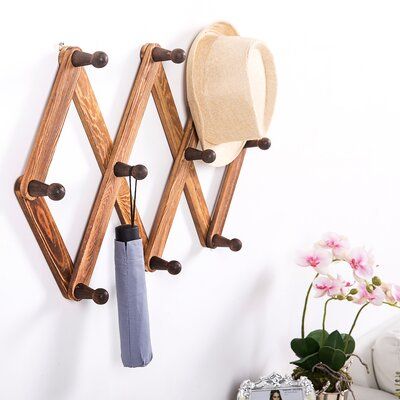 Red Barrel Studio® Don't let your home get cluttered, keep it organized with this wall mounted coat rack. The accordion design lets you contract and expand the rack to fit any space, allowing to you display is vertically or horizontally. You can easily mount this hook rack to your wall with proper mounting hardware. Ten dark wood pegs and naturally stained slats let you incorporate this decorative coat rack into any space. Display this wooden coat rack in an entryway for hanging coats, hats, pur Peg Coat Rack, Torch Wood, Hanging Hats, Burnt Wood, Wall Mount Rack, Wooden Coat Rack, Wood Rack, Rustic Wood Walls, Hook Wall