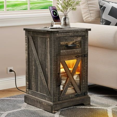 Introducing our versatile Nightstand with Charging Station, a charming addition to your living space. This farmhouse-inspired end table features LED lights for a cozy ambiance. Enhanced with a barn door and adjustable storage shelf, it combines functionality with style. Crafted from rustic wood, this table adds warmth to your living room or bedroom. Charge your devices conveniently while enjoying the elegant design. Specifications: Color: Dark Rustic Oak Material: Engineered Wood Item Weight: 31 Modern Farmhouse Nightstand, Farmhouse Table Base, Boho Bedside Table, Farmhouse End Table, Farmhouse Nightstand, Table With Charging Station, Shelf Nightstand, Farmhouse End Tables, Modern Farmhouse Table