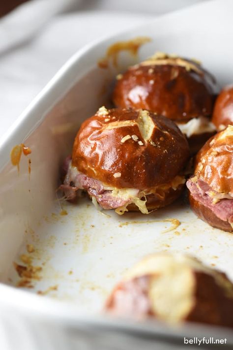 Reuben Pretzel Sliders combine all the classic Reuben goodies onto small pretzel rolls, with a killer sauce that coats the buns as they bake. Great crowd pleaser for parties or an easy weeknight dinner! #reubensliders #reubensliderseasy #reubenslidersrecipe #reubensandwich #saintpatricksdayfood #stpatricksdayfood Pretzel Buns Sandwich, Pretzel Bun Sliders, Pretzel Sliders, Reuben Sliders, Reuben Recipe, Ham Balls, Kielbasa And Cabbage, Pretzel Rolls, Pretzel Bun