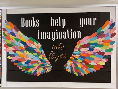 Library bulletin board with multicolor wings and text that says “Books help your imagination take flight” Angel Wings Bulletin Board, Bird Theme Decorating Ideas, Imagination Bulletin Board Ideas, Feather Bulletin Board, Watch Us Soar Wings Bulletin Board, Decorated Doors For School, Wings Bulletin Board Ideas, Reading Gives You Wings Bulletin Board, Wing Bulletin Board