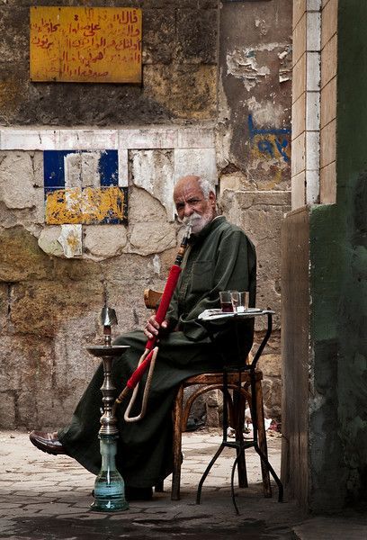 Man smoking shisha outside an ahwa in the Darb-al-Ahmar residential district. Downtown Egypt, Egyptian Streets, Downtown Cairo, The Symbiotic Relationship Between, Life In Egypt, Ancient Tomb, Modern Metropolis, Old Egypt, The Butcher