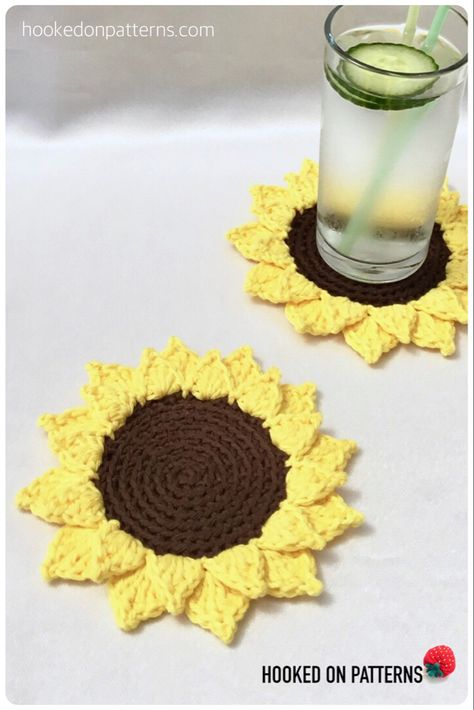 Crocheted sunflower coasters displayed with a glass of cool water Crochet Pineapple Coasters, Crochet Sunflower Coasters Free Pattern, Free Sunflower Crochet Pattern, Crocheted Sunflower, Crochet Sunflowers, Sunflower Coaster, Sunflower Coasters, Coasters Free Pattern, Plant Crochet