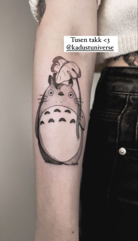 A tattoo of my neighbour totoro holding a leaf. The tattoo is located on the under arm of a woman Totoro Umbrella Tattoo, Totoro Tattoo Minimalist, Totoro Tattoo, Cute Totoro, Studio Ghibli Tattoo, Ghibli Tattoo, Tattoo Sleeve, My Neighbor Totoro, Anime Tattoos