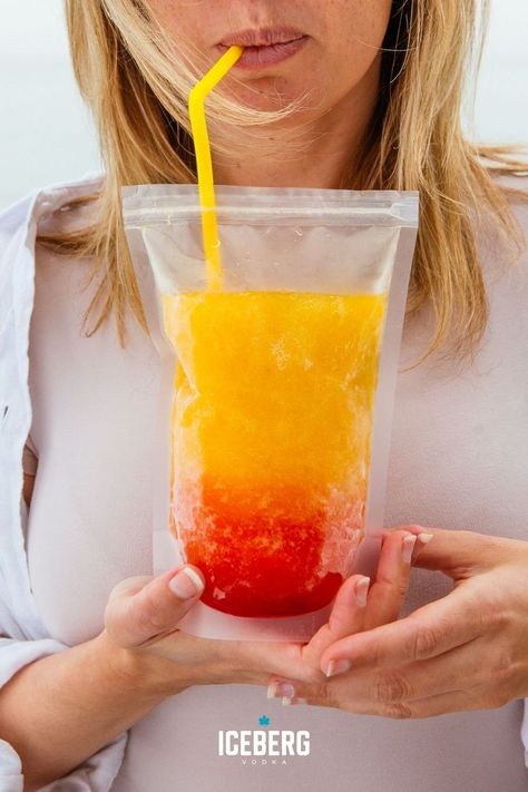 A woman holds a clear drink pouch filled with red and orange vodka slushie summer drink. Pouch Drinks Alcohol Recipes, Adult Capri Sun Recipe, Adult Capri Sun, Vodka Slushies, Best Vodka Cocktails, Mango Vodka, Frozen Drinks Alcohol, Vodka Sunrise, Mango And Pineapple