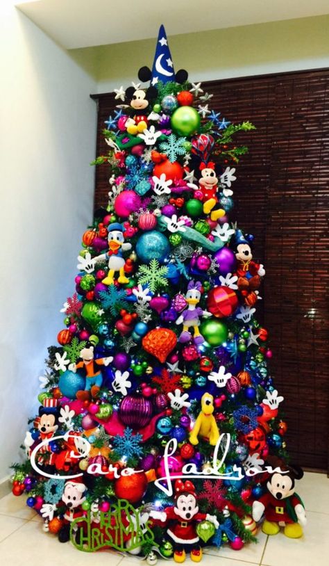 As Christmas approaches, children begin insisting on going to Disneyland to spend the holidays. But it isn’t always possible to take a leave and visit the gorgeous place. But there’s one thing you can always go, transform your house into Disneyland. Yes, we’re talking about Disney Christmas... Mickey Mouse Tree, Colored Christmas Tree, Mickey Mouse Christmas Tree, Amazing Christmas Trees, Disney Christmas Decorations, Disney Christmas Tree, Christmas Trees For Kids, Ribbon Ideas, Tree Ribbon