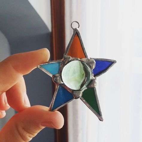 "Pretty, multi-colored star suncatcher, designed and created by me, using the copper foil method of stained glass. Made from the remnants of a church renovation in Des Moines. Equally pretty hanging in a window or from a Christmas tree. Design available in a variety of colors. Silver edging. Approximately 2 1/2\" tall by 2 1/2\" wide." Small Stained Glass Suncatchers, Star Suncatcher, Stained Glass Star, Foil Method, Star Celestial, Glass Suncatchers, Stained Glass Ornaments, Jo Jo, Whimsical Gifts